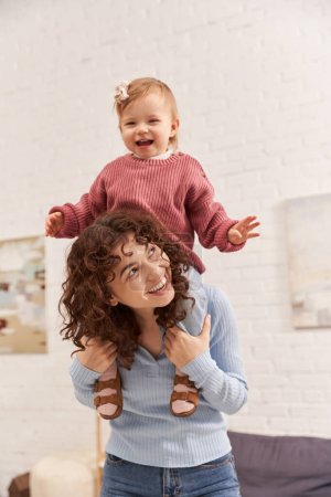 Foto de Tiempo de calidad, trabajo y armonía de la vida, mujer alegre con la muchacha emocionada del bebé en hombros, estilo de vida equilibrado, tiempo de la hija de la mamá, divertirse juntos, maternidad cariñosa, felicidad - Imagen libre de derechos
