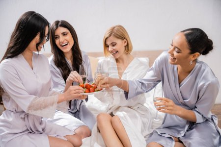 strawberries and champagne, happy four women, bridal party, interracial girlfriends having fun, brunette and blonde, bride and her bridesmaids spending time together, cultural diversity, bedroom 