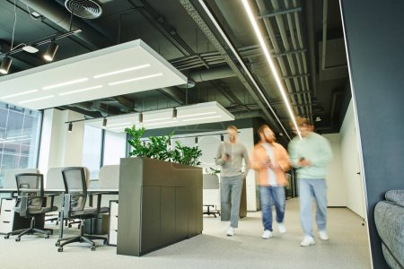 group of creative business partners walking in modern and spacious coworking space with high tech interior, contemporary furniture and green natural plants, movement, long exposure