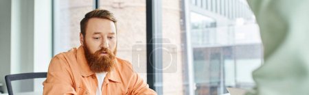 thoughtful and bearded designer in stylish casual clothes thinking while working in contemporary coworking office, creative thinking, architectural business, banner