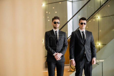 security guards, two handsome men in formal wear and sunglasses, bodyguards on duty, safety measures, vigilance, black suits and ties, private security, strong men 