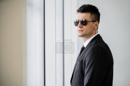 professional headshots, bodyguard work, good looking man in sunglasses and black suit with tie, hotel safety, security management, surveillance and vigilance, uniformed guard on duty