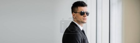 Photo for Professional headshots, bodyguard work, good looking man in sunglasses and black suit with tie, hotel safety, security measurements, surveillance and vigilance, uniformed guard on duty, banner - Royalty Free Image