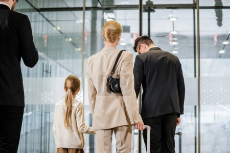security service, personal protection, back view of blonde woman and her daughter leaving hotel next to bodyguards, private safety, rich lifestyle, guards on duty 