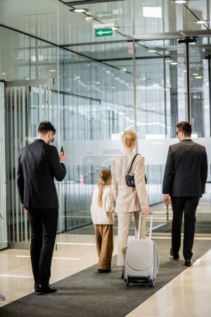 personal protection, bodyguards in formal wear and sunglasses escorting blonde woman and her daughter, leaving hotel, private safety, rich lifestyle, security service 