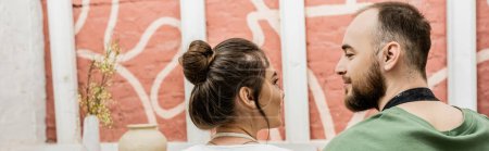 Téléchargez les photos : Artisan barbu regardant petite amie brune près de l'argile dans l'atelier de poterie, bannière - en image libre de droit