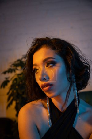 Téléchargez les photos : Confiant jeune asiatique femme avec soirée visage passer du temps en boîte de nuit avec soirée - en image libre de droit