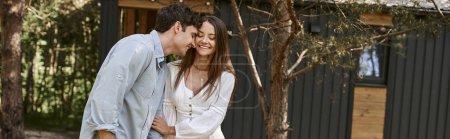 pancarta, pareja positiva, hombre y mujer felices en vestido de fiesta cogidos de la mano cerca de la casa de vacaciones, verano