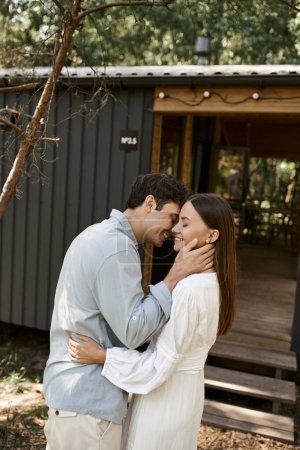 couple in love, handsome man hugging beautiful woman near vacation house, summer getaway, romance