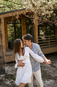 happiness and laughter, happy man hugging woman near vacation house, summer love and romance Poster #666378402