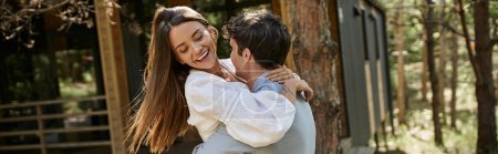banner, joy, happy woman hugging with boyfriend near vacation house in forest, love, romantic couple