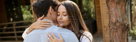 Young woman with closed eyes embracing brunette boyfriend near vacation house outdoors, banner