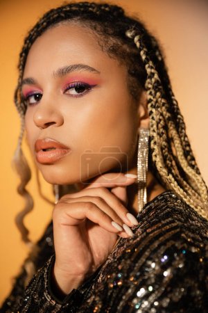 portrait of beautiful african american woman looking at camera, bold makeup, manicure, beauty