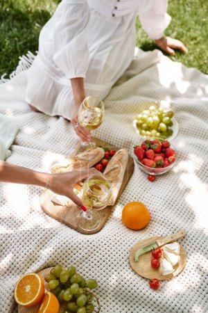 vista recortada de novias afroamericanas con copas de vino, frutas y verduras, picnic de verano