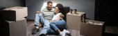 smiling african american couple hugging near carton boxes and takeaway coffee in new house, banner Poster #667986990