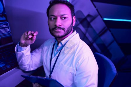 Futuristische Kontemplation: Hindu-Wissenschaftler reflektiert inmitten von Neonlichtern im Science Center der Zukunft