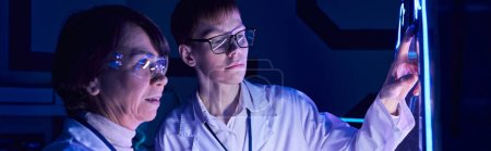 Junge Praktikantin bedient Experimentiergeräte im neonbeleuchteten Entdeckungszentrum der Zukunft