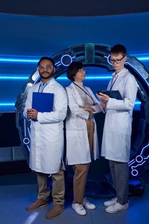 Concept futuriste, équipe scientifique multiethnique avant-gardiste à proximité de nouveaux équipements dans un centre scientifique