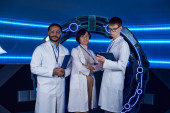 future-oriented multiethnic scientists looking at camera near innovative device in discovery center magic mug #668555372