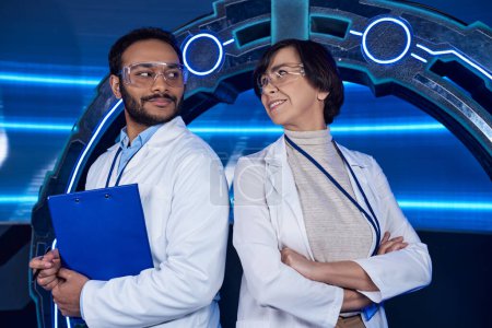 innovative lab, multiethnic scientists smiling at each other near neon-lit experimental device