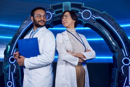 creative multiethnic scientists looking at each other near neon-lit  device in science center