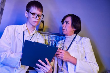 woman scientist and young intern working on otherworldly exploration in innovation laboratory