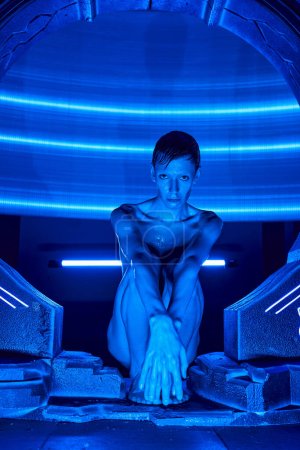 Photo for Innovation hub, extraterrestrial humanoid alien sitting in experimental hub in neon light - Royalty Free Image