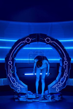 Foto de Exploración científica, humanoide alienígena mirando las piernas en el dispositivo experimental en el centro de descubrimiento - Imagen libre de derechos