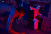 extraterrestrial humanoid crawling near scientist in hazmat suit showing stop gesture in lab magic mug #668557696