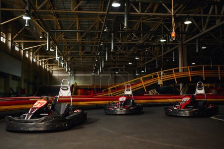 coches de carreras modernos dentro del circuito de karts de interior, vehículos deportivos de carreras de motor, karting de carreras de velocidad