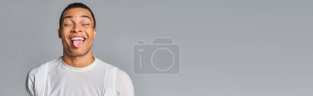 Téléchargez les photos : Homme afro-américain en t-shirt tendance, les yeux fermés, collant sur le gris, bannière, espace de copie - en image libre de droit