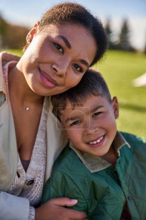 portrait of happy african american woman and boy, mother and son hugging, love and bonding