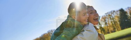 candid, free spirit, excited mother piggybacking son, african american woman and boy, autumn, banner