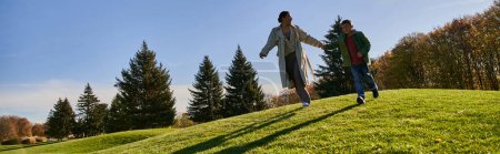 sonniger Herbsttag, fröhliche afrikanisch-amerikanische Frau läuft mit Sohn im Park, offen, Transparent