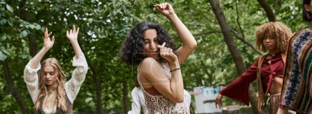 positive multiracial woman dancing near blurred girlfriends outdoors in retreat center, banner