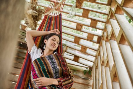 women retreat concept, happy young woman relaxing in hammock in cottage, top view