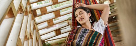pleased woman in boho style clothes resting in hammock, retreat, harmony, rejuvenation
