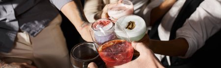 Téléchargez les photos : Vue recadrée de collègues multiethniques qui claquent des verres avec des boissons alcoolisées dans un bar à cocktails, bannière - en image libre de droit