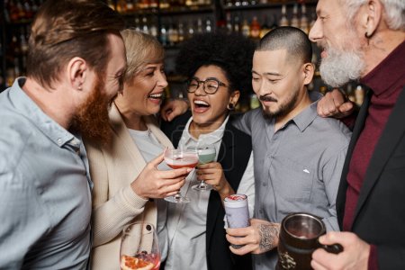 lachende Afroamerikanerin beim Gläserklirren mit multiethnisch erfolgreichen Kollegen in Bar
