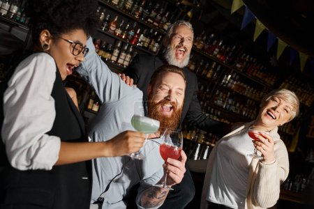 Téléchargez les photos : Plaisir de collègues multiethniques avec des cocktails riant au bar, équipe diversifiée s'amuser après le travail - en image libre de droit