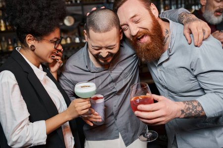 aufgeregte bärtige Männer und afrikanisch-amerikanische Frau lachen in Bar, Freizeit multiethnischer Arbeitskollegen
