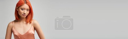 portrait of beautiful young asian woman in silk slip dress posing on grey backdrop, banner