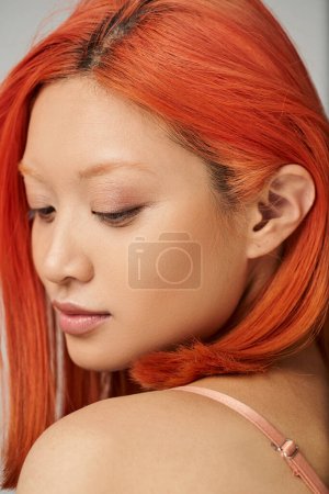 Téléchargez les photos : Portrait de séduisante jeune femme asiatique avec une peau parfaite et un maquillage naturel sur fond gris - en image libre de droit
