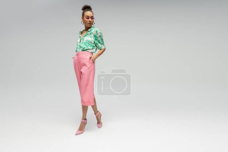 Photo for Stylish african american woman in pink sunglasses and stylish attire posing on grey backdrop - Royalty Free Image