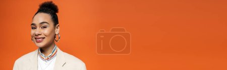 Photo for African american model with vivid makeup and hoop earrings looking and smiling at camera, banner - Royalty Free Image