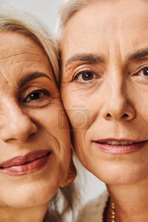 close-up portrait of positive senior women with makeup looking at camera in studio, timeless beauty