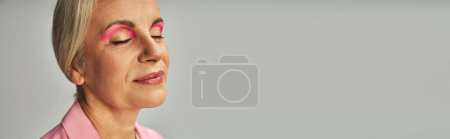 Photo for Close-up portrait of mature lady with natural makeup smiling with closed eyes on grey , banner - Royalty Free Image