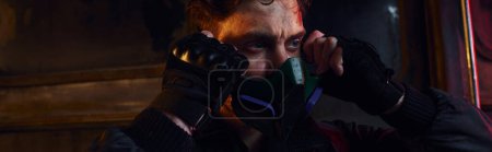Photo for Portrait of game character with scratched face wearing gas mask in post-apocalyptic subway, banner - Royalty Free Image