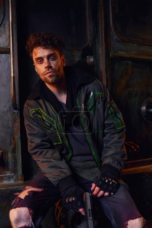 injured unshaven man in dirty clothes sitting near rusty carriage in post-apocalyptic subway puzzle 675367464