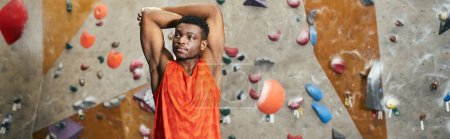 handsome sporty african american man with hands behind his head looking away, climbing, banner